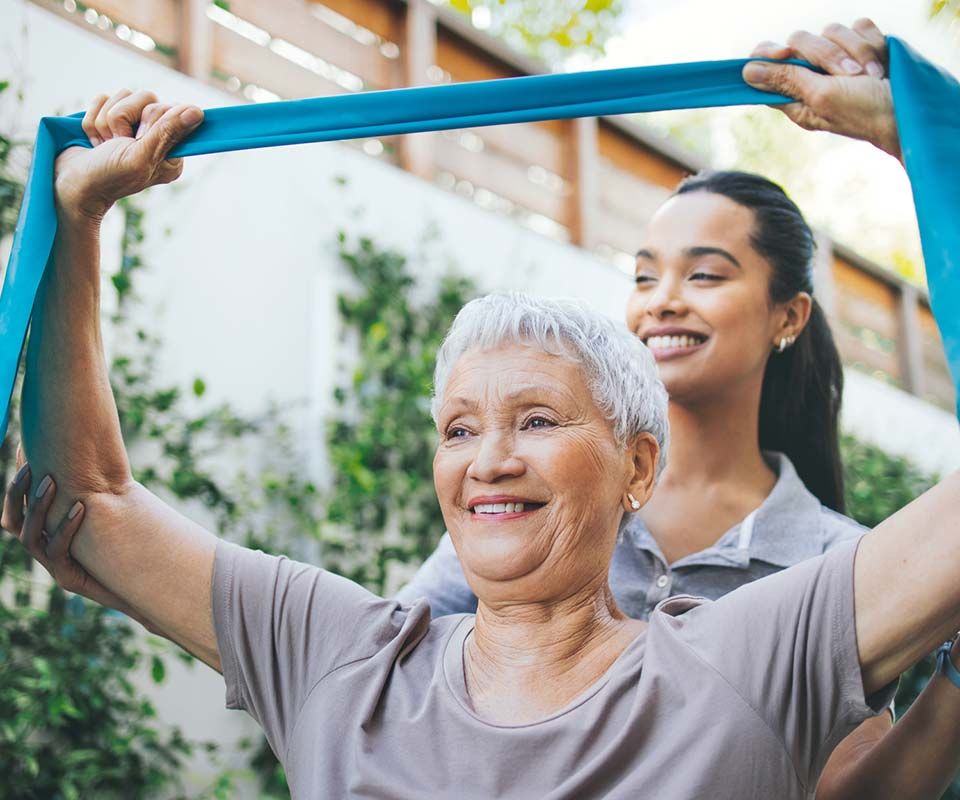 Intern leading movement therapy with a senior woman